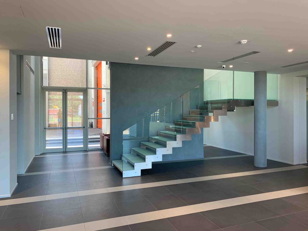 Scala interna in metallo con parapetto e gradini in vetro