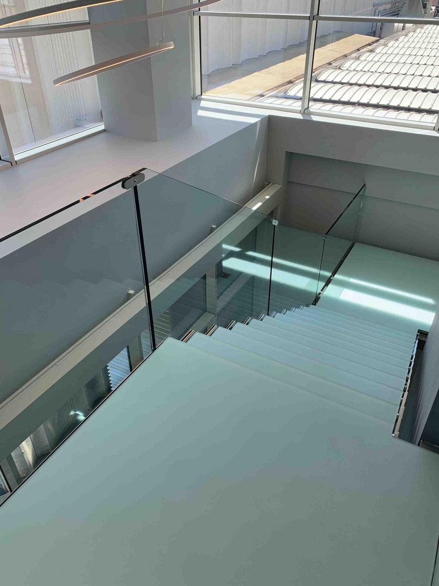 Scala interna in metallo con parapetto e gradini in vetro