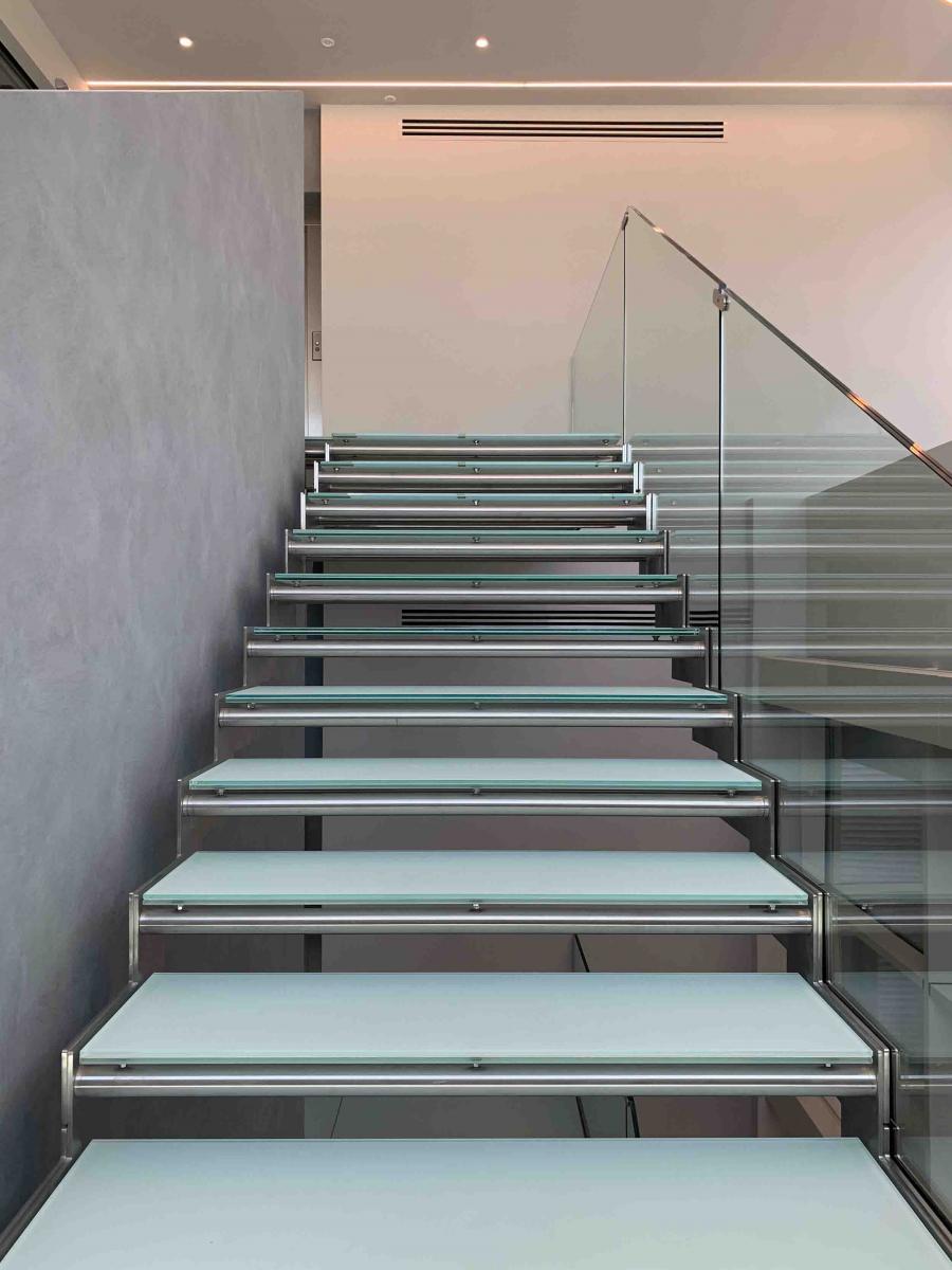 Scala interna in metallo con parapetto e gradini in vetro