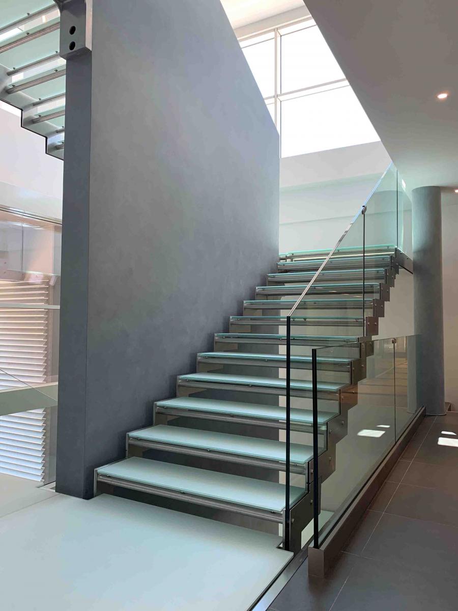 Scala interna in metallo con parapetto e gradini in vetro