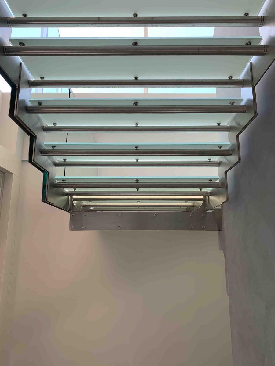 Scala interna in metallo con parapetto e gradini in vetro