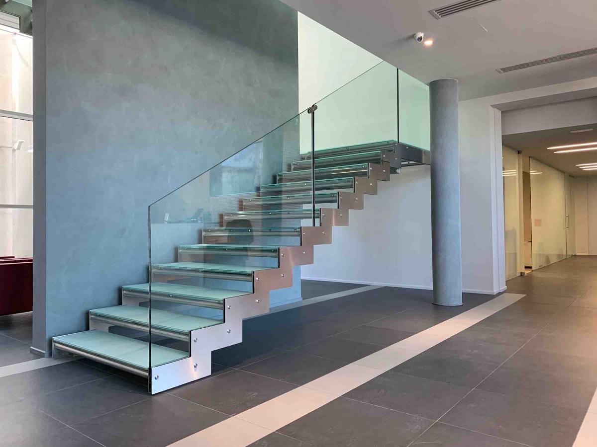 Scala interna in metallo con parapetto e gradini in vetro